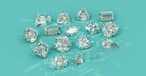 Collection of loose 5-carat diamonds in various shapes including trillion, radiant, and cushion cuts on a teal surface.