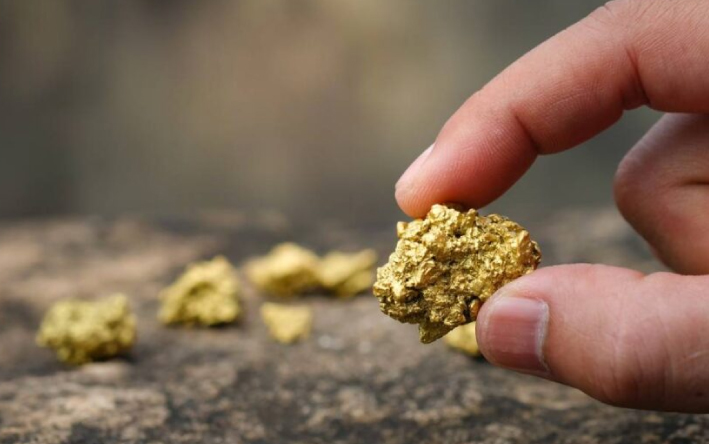 closeup of gold held in a mans fingers