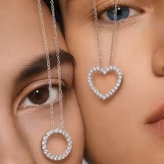 Model wearing a diamond heart pendant necklace and circular diamond pendant — Lab-grown diamond gifts for her