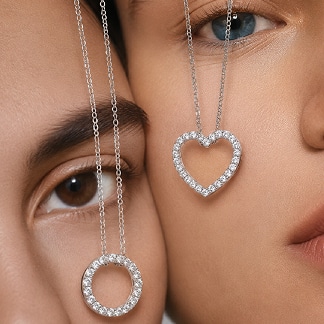 Model wearing a diamond heart pendant necklace and circular diamond pendant — Lab-grown diamond gifts for her