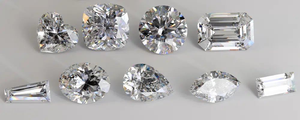 Assorted loose lab-grown diamonds demonstrating heart, cushion, round, emerald, oval, pear, and marquise facet cuts.