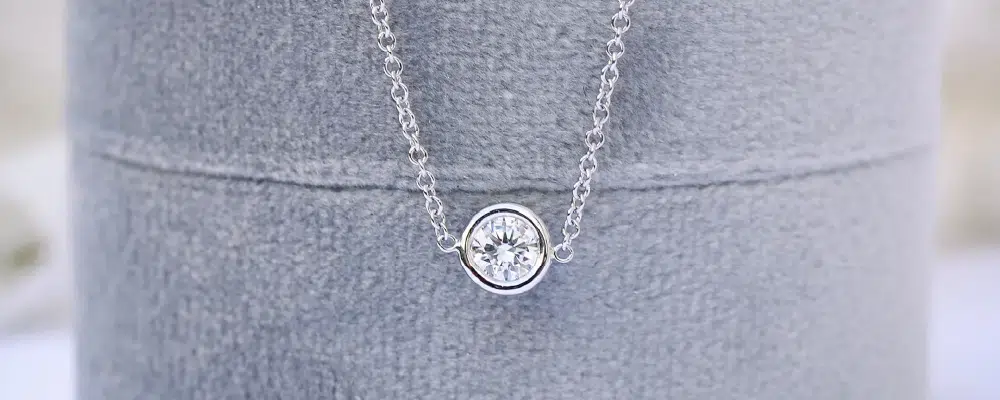 Round brilliant lab-grown diamond bezel solitaire pendant necklace in 14k white gold.