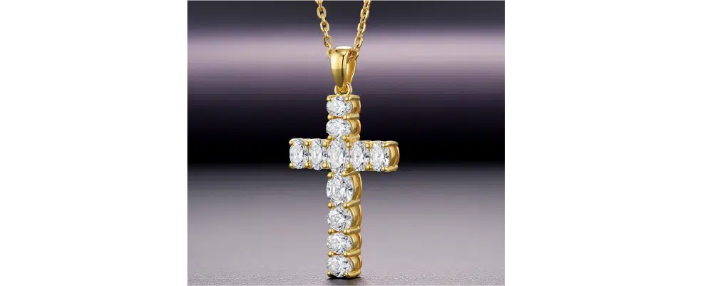 A structured yellow gold cross pendant featuring inline prong-set oval cut diamonds