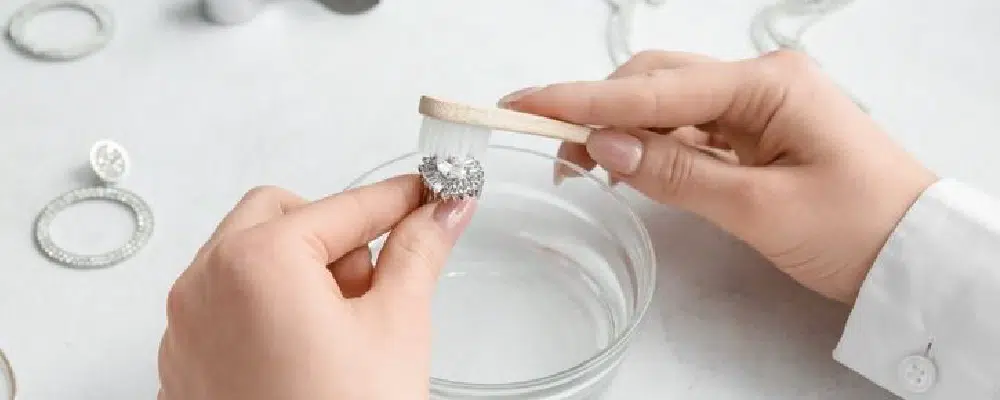 How to clean a halo engagement ring setting by carefully scrubbing with a small brush over a bowl of cleaning solution.