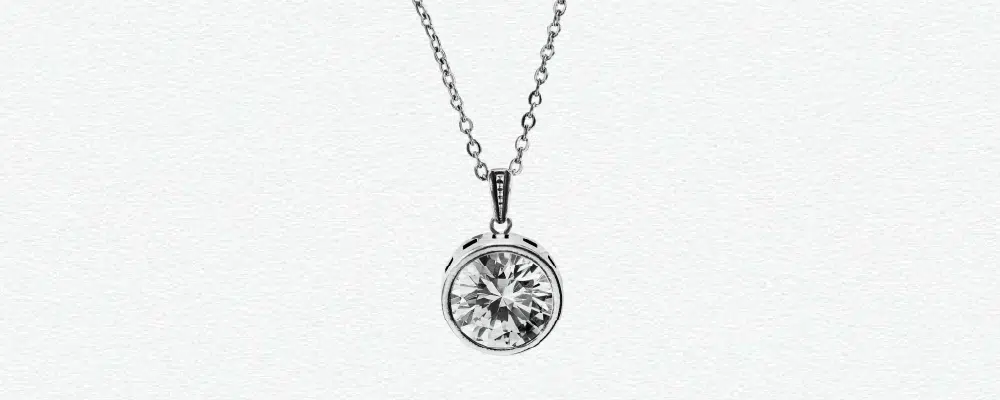 Round brilliant lab-grown diamond bezel solitaire pendant necklace in 14k white gold.