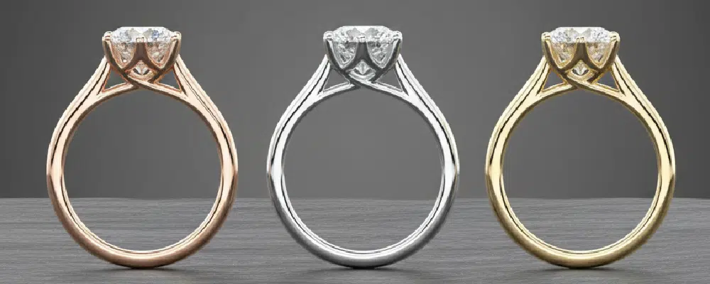 Three cathedral solitaire engagement rings in rose gold, white gold, and yellow gold, illustrating popular metal design choices.