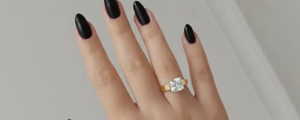 Person wearing a wide-band solitaire engagement ring with a large cushion cut diamond, demonstrating how a thick band looks on a finger for daily wear.