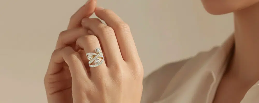Close up of a woman wearing a modern retro lab grown diamond cocktail ring with an intricate multi band gold wrap design.
