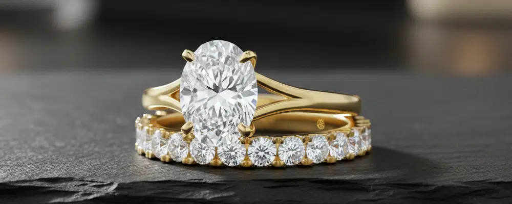 Oval lab-grown diamond engagement ring and round diamond eternity band in 18k yellow gold.