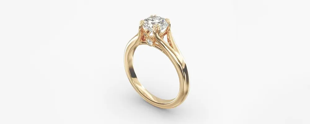 An elegant yellow gold split shank solitaire engagement ring holding a round brilliant cut diamond