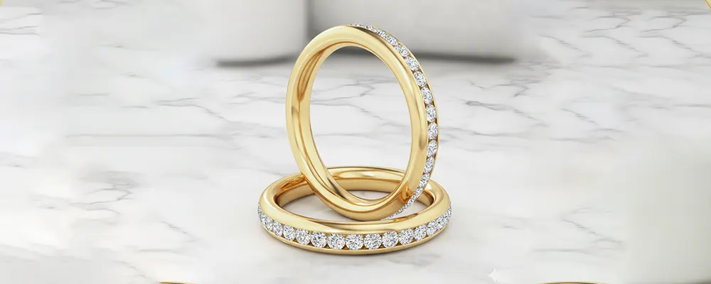 Channel-set round brilliant lab-grown diamond eternity wedding bands in 18k yellow gold.
