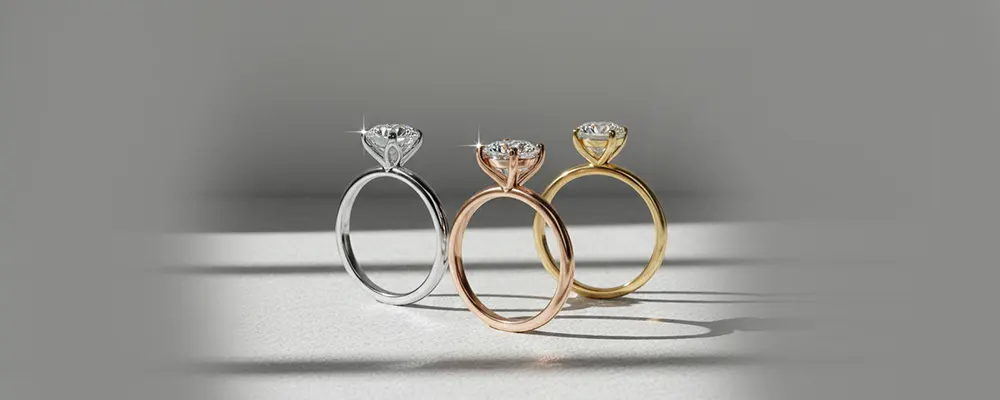 Three classic plain band solitaire engagement rings shown in white gold rose gold and yellow gold casting shadows