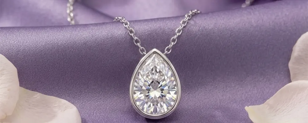 A bezel set pear shaped diamond pendant necklace