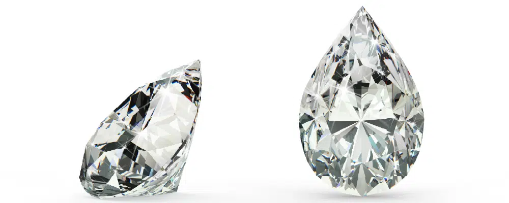 Two loose pear cut diamonds shown from the side and top view to illustrate the teardrop silhouette prior to a custom bezel setting