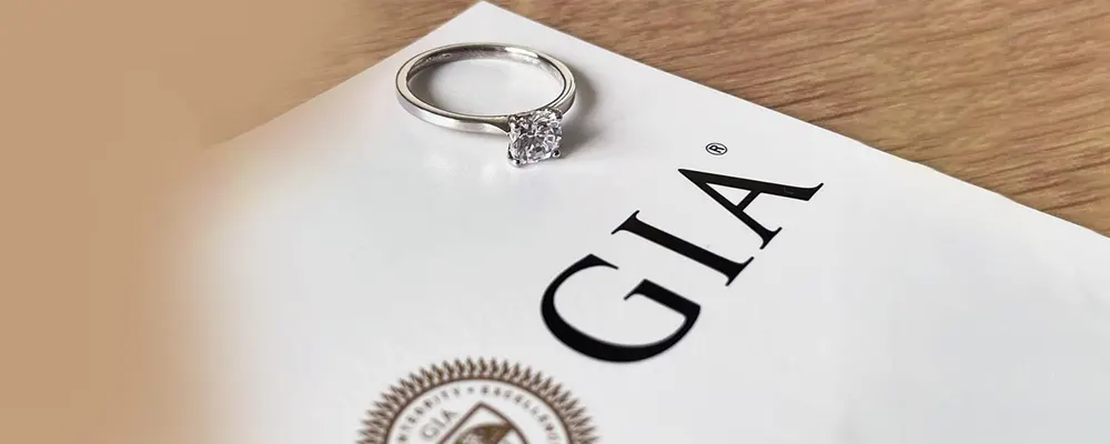 A classic round brilliant cut diamond engagement ring resting on an official GIA grading certificate report.
