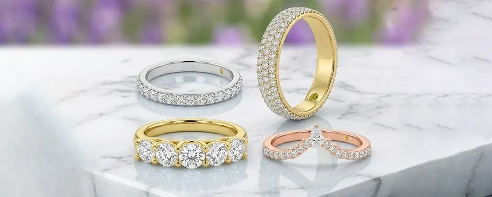 Assorted lab grown diamond eternity rings and chevron bands in yellow, white, and rose gold