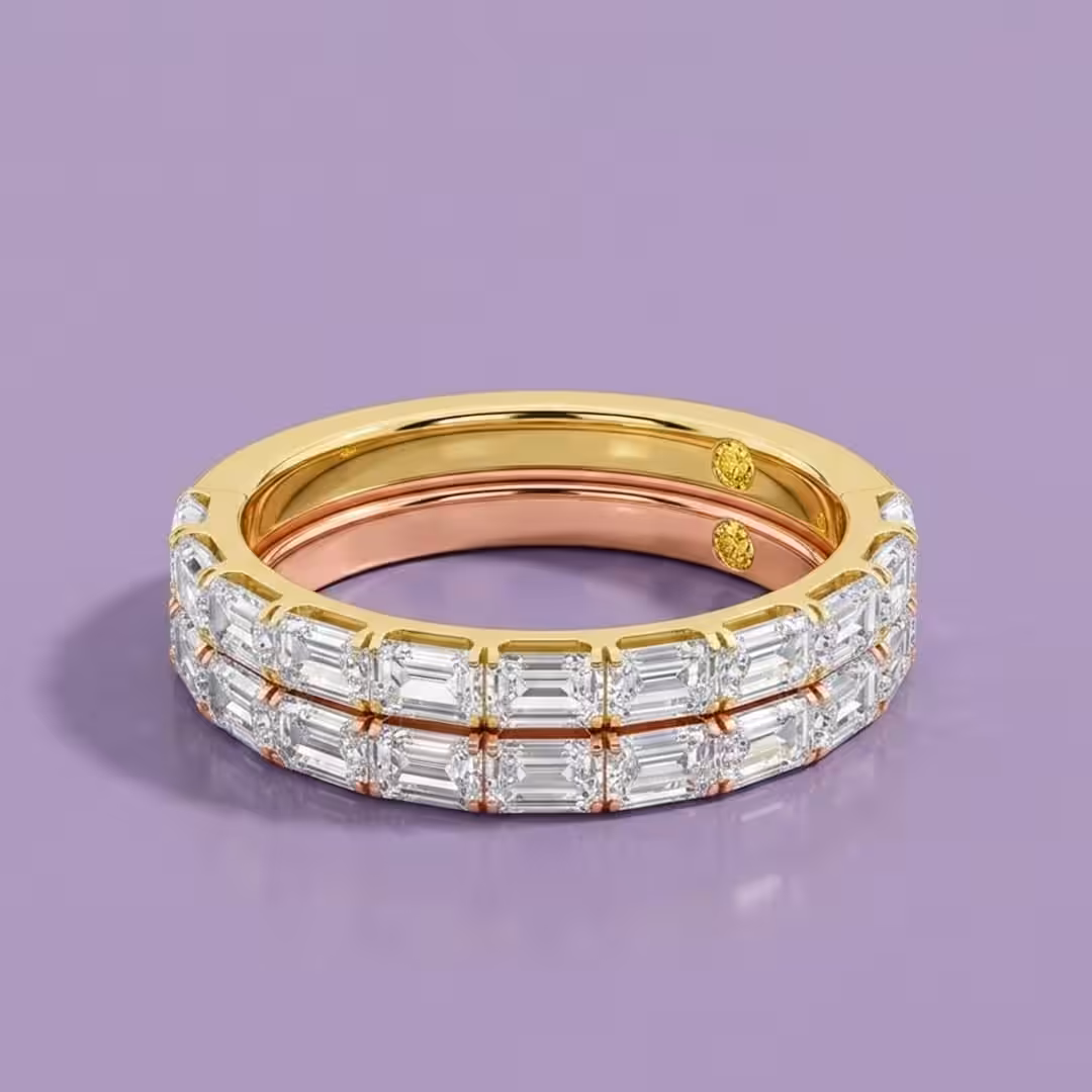 A yellow gold and a white gold wedding band, both featuring emerald-cut lab-grown diamonds, stacked on a purple background.