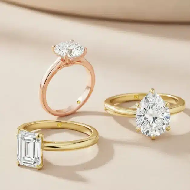 Collection of diamond engagement rings including rose gold round solitaire, yellow gold pear cut, and emerald cut solitaire for resale value comparison